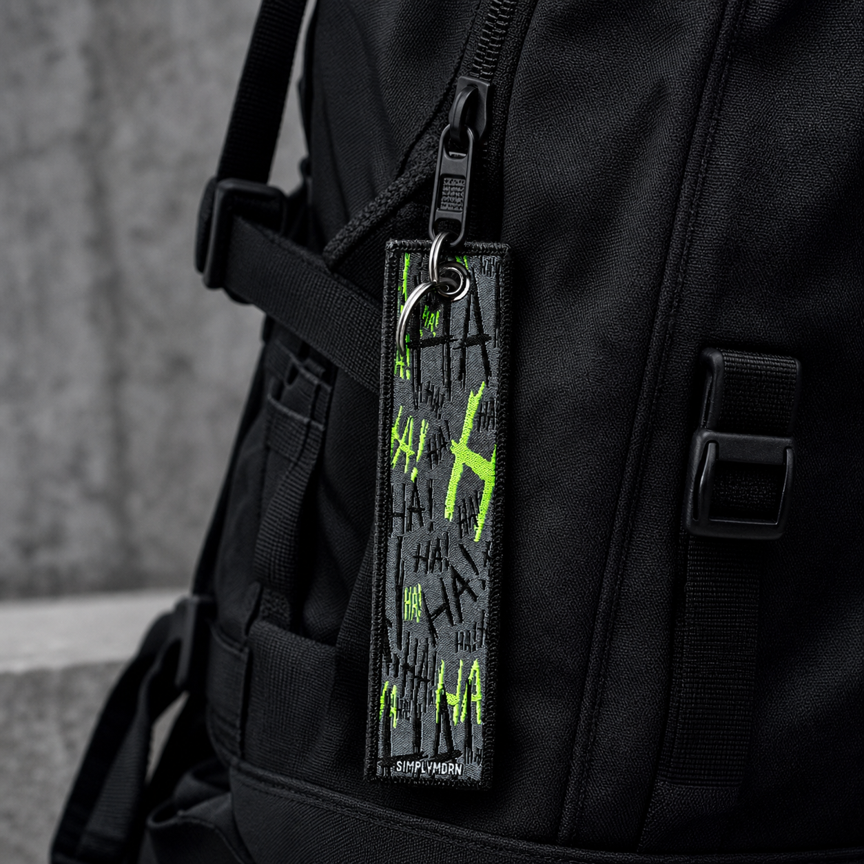 JOK3STER embroidered keychain attached to a black backpack zipper