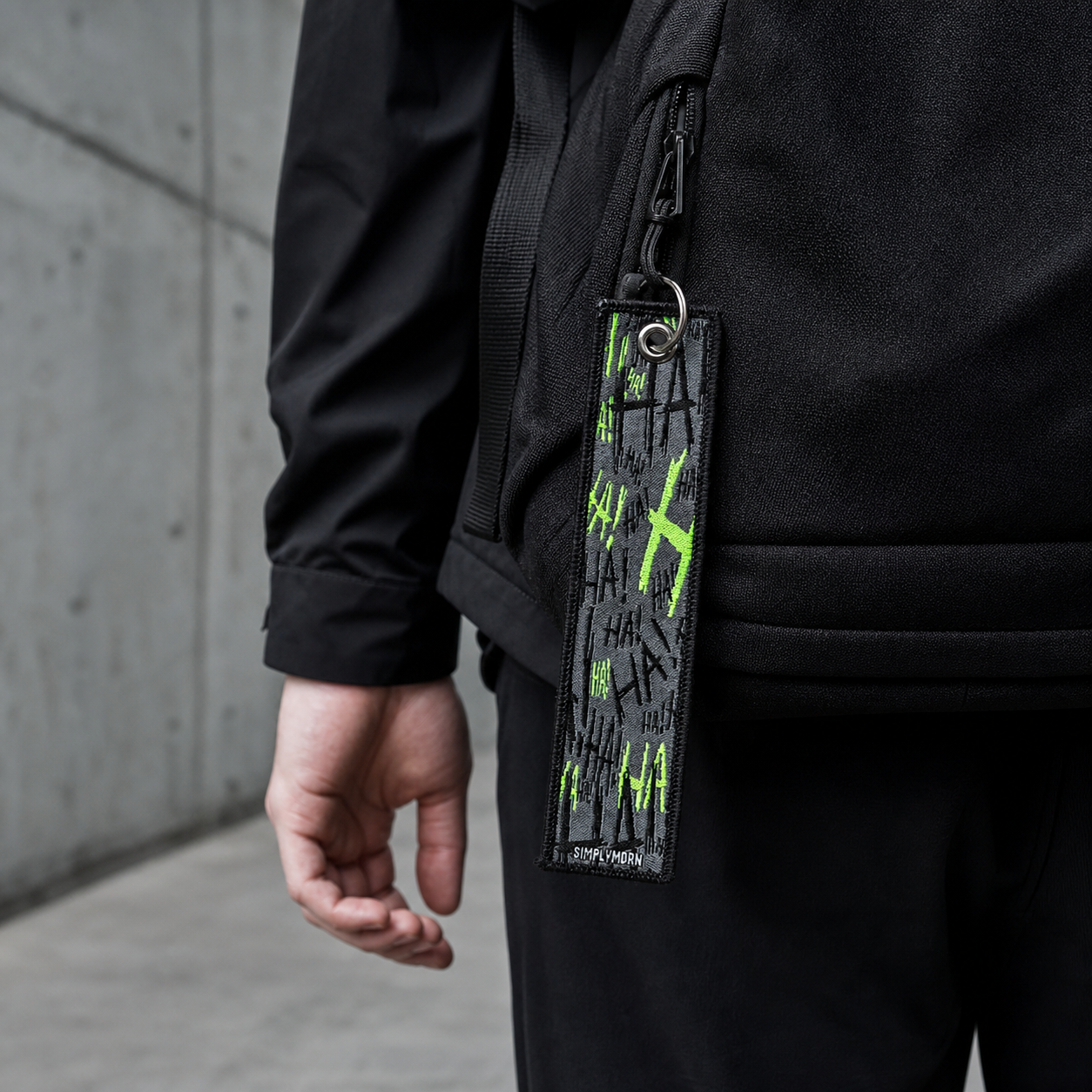 Embroidered mystery keychain attached to a black technical backpack